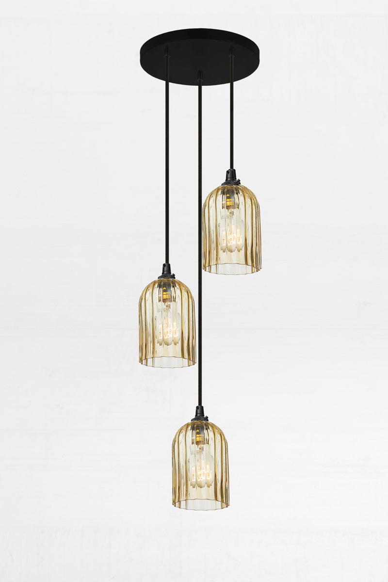 Three fluted amber glass shades, paired with a black circular ceiling rose and cords. 