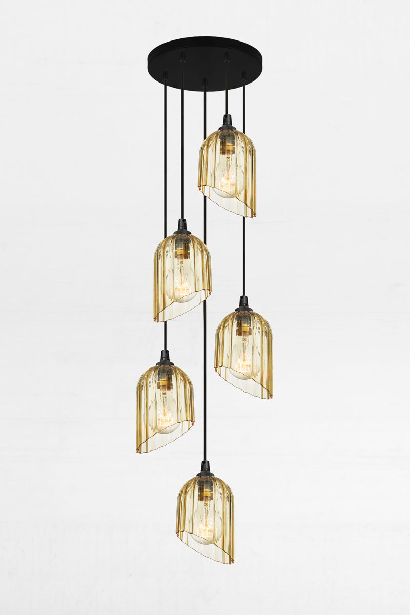 Five fluted amber glass shades with an angled cut detail, paired with a black circular ceiling rose and cords. 