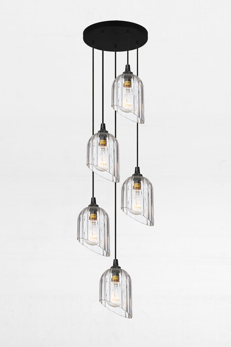 Five fluted clear glass shades with an angled cut detail, paired with a black circular ceiling rose and cords. 