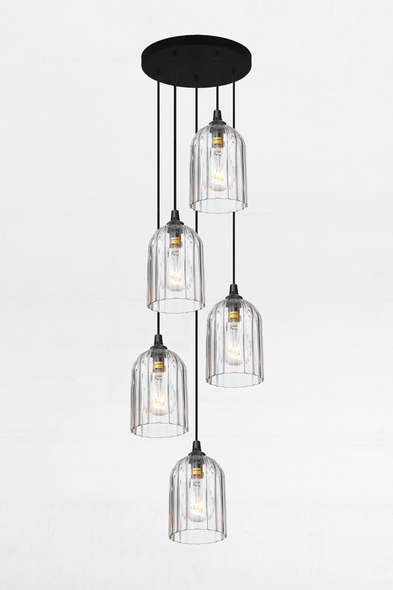 Five fluted clear glass shades, paired with a black circular ceiling rose and cords. 