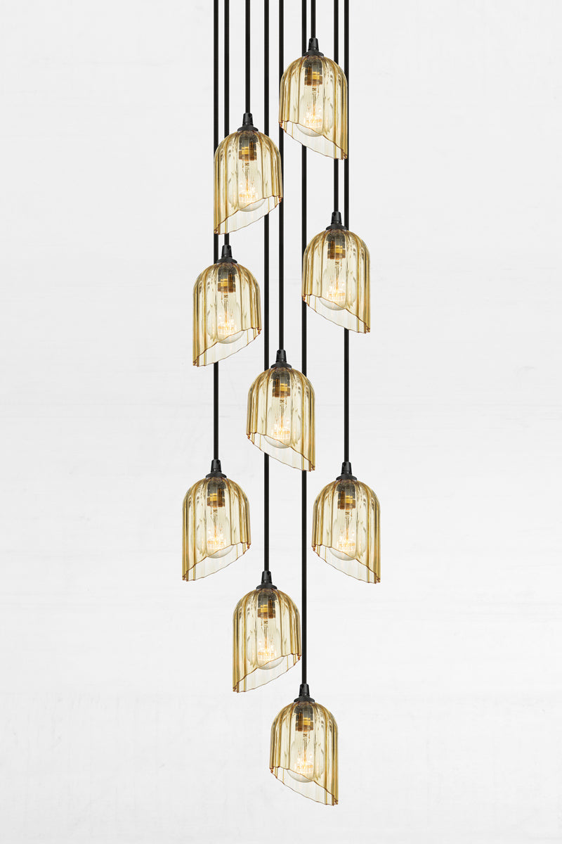 Nine fluted amber glass shades with an angled cut detail, paired with a black circular ceiling rose and cords. 