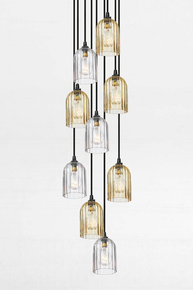 Nine fluted glass shades in amber and clear, paired with a black circular ceiling rose and cords. 