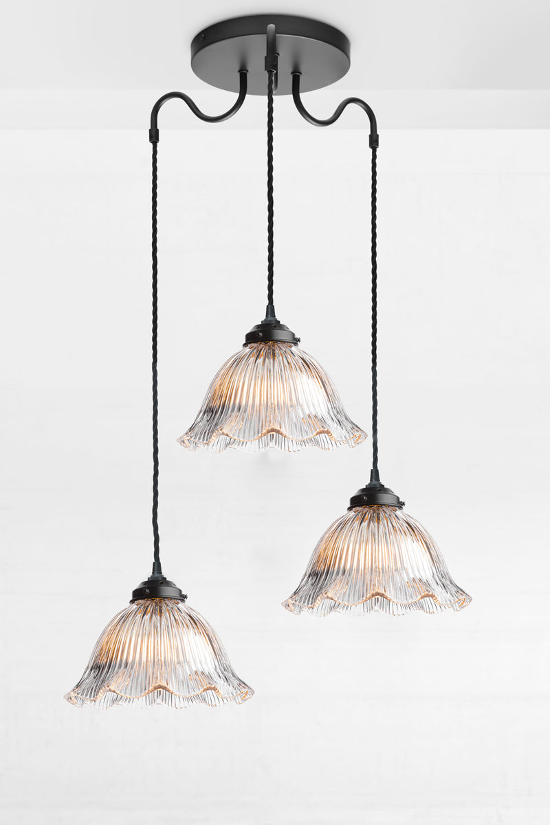 Vintage inspired 3 gooseneck arm multi drop light with black twisted cords and clear glass shades with holophane detailing and a filled edge. 