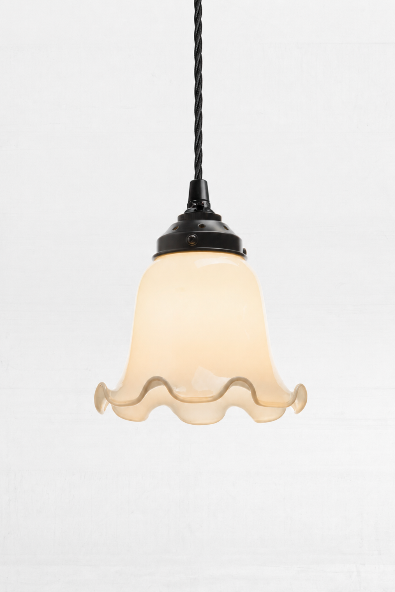 Opal glass bell shaped shade with scalloped edging, paired with black harewar and twisted cloth cord. 