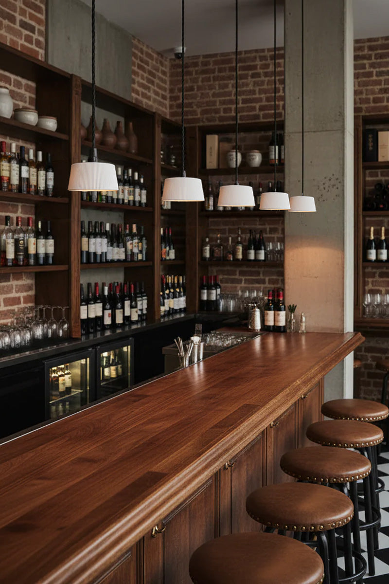 Five white paper pendant lights over a bar area. 