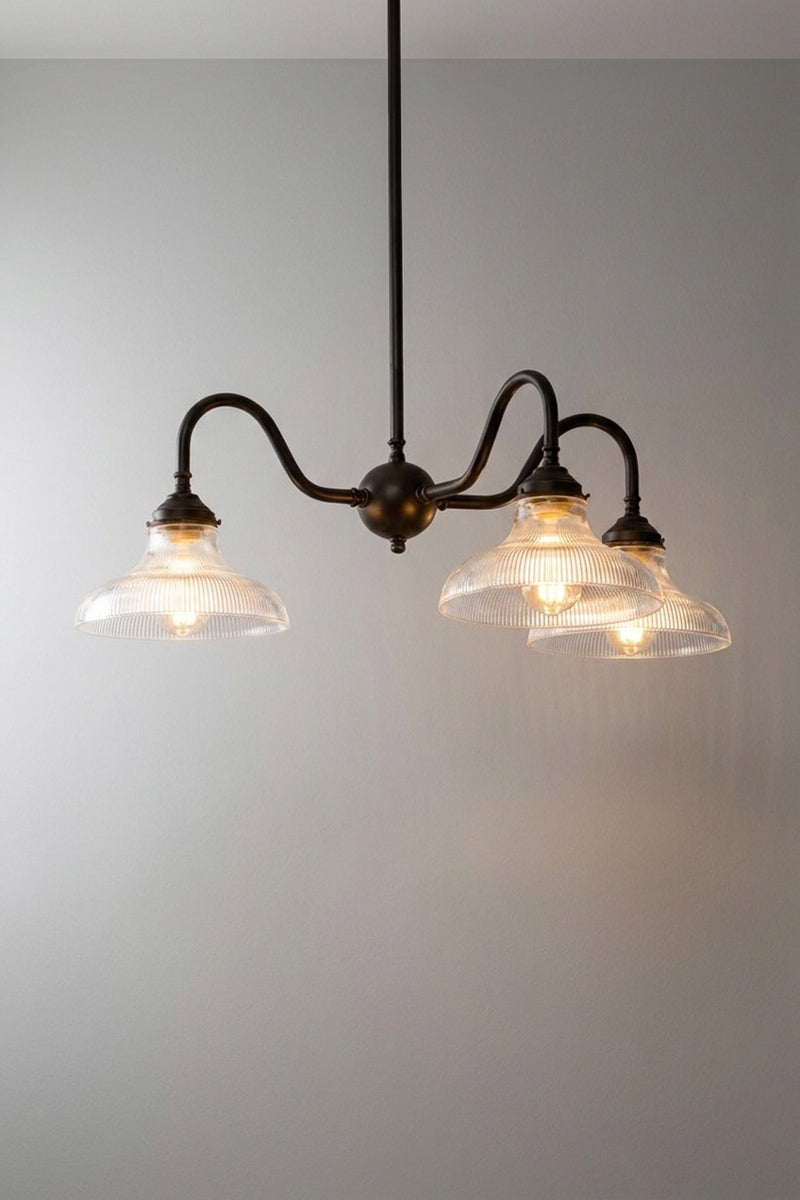 A three-light chandelier with a black steel frame and ribbed clear glass shades.
