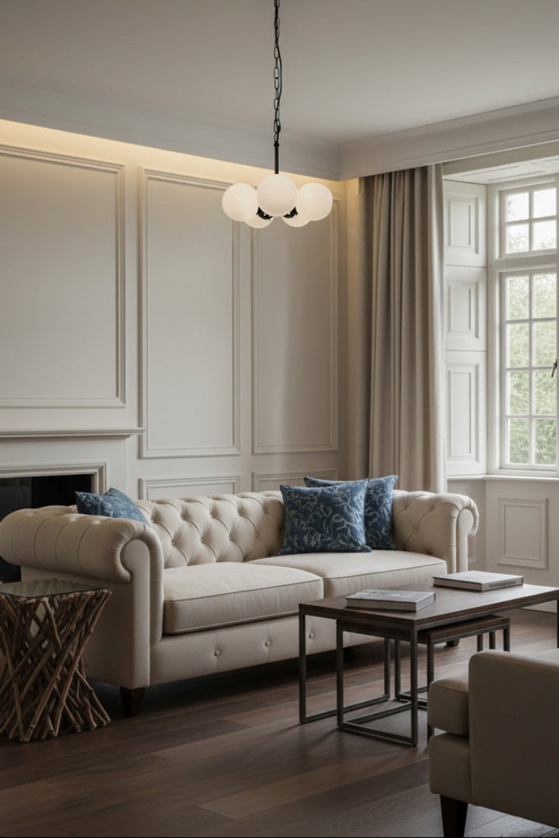 living room with beight couch and 5 light pendant with opal shades