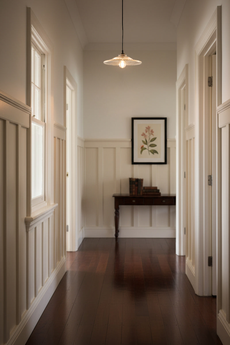 glass pendant light in hallway with floor boards