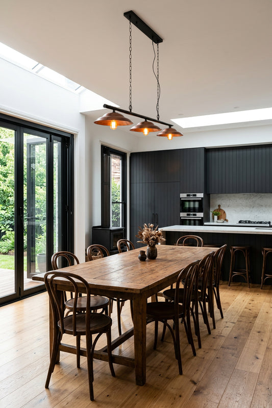 Copper barn shade triple swing pendant in a bright modern kitchen.