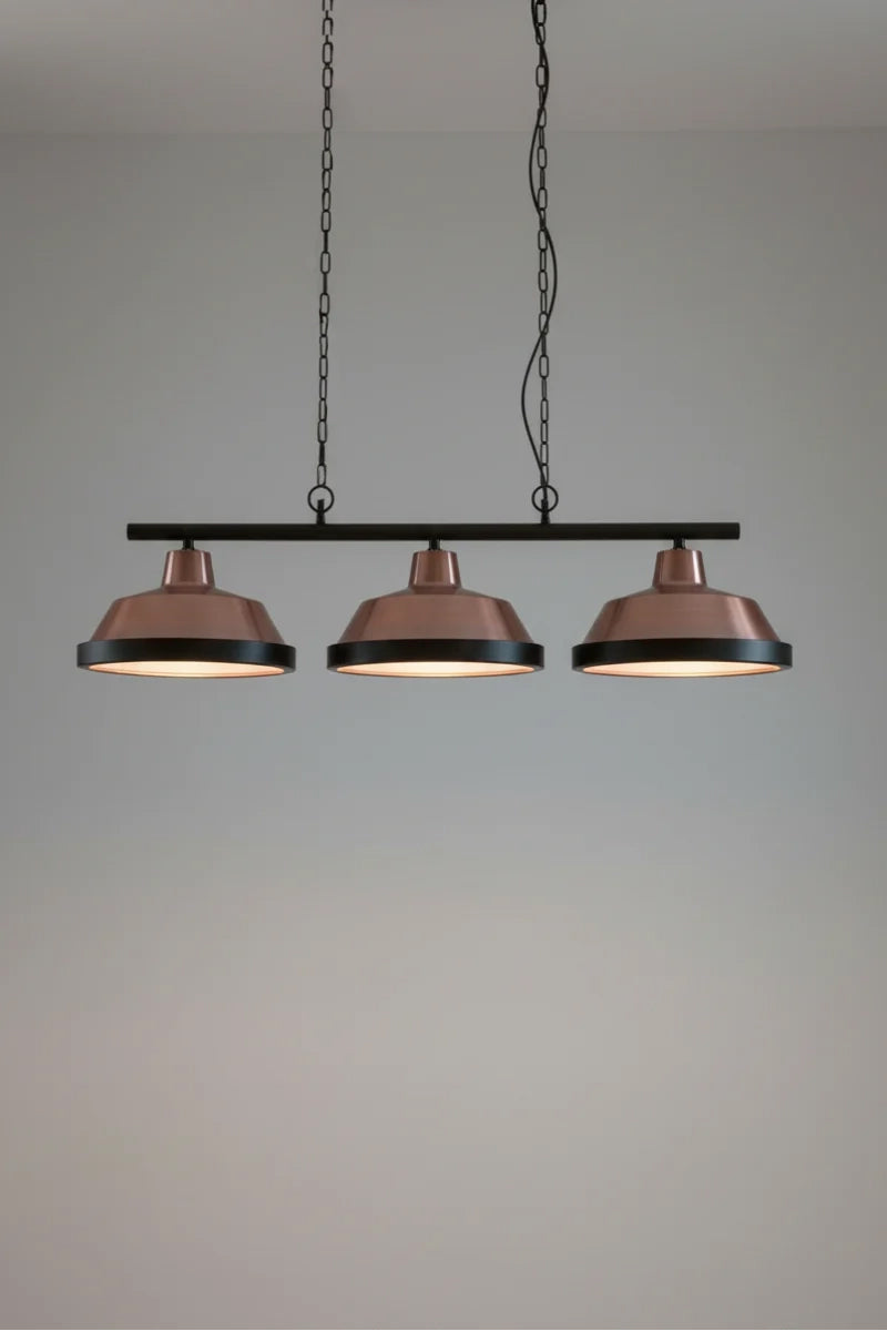 Vintage-style swing pendant light with three solid copper shades on black fitting with frosted glass and matt black covers. 