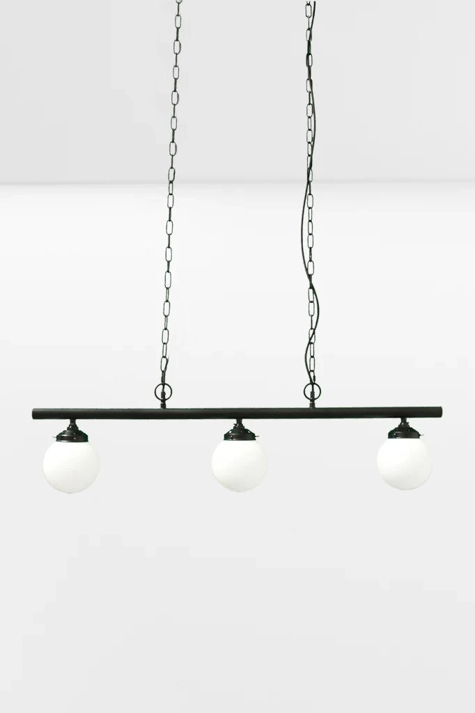 Small opall shades on the three light linear bar light with black chains. 