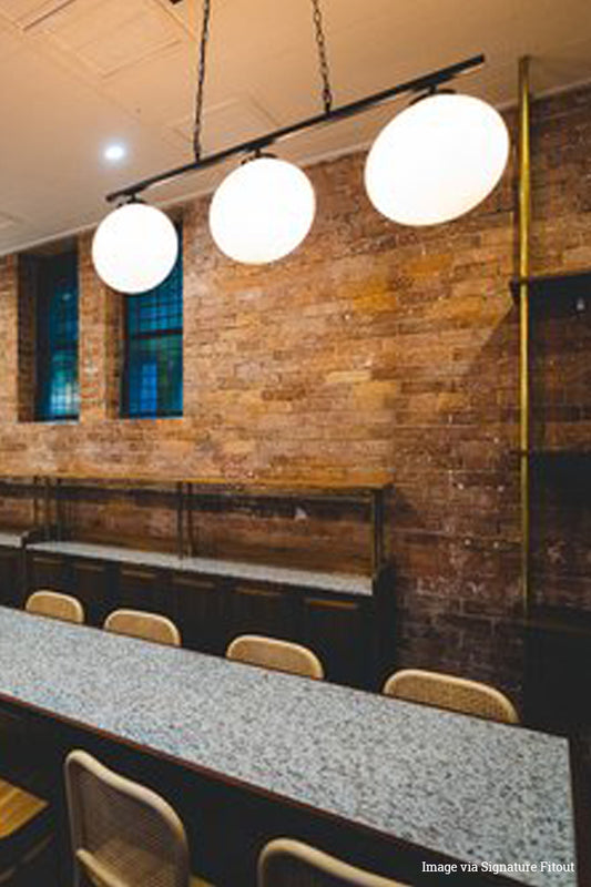 Close up of the Glass Ball Swing Pendant image in restaurant via Signature Fitout