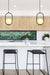 Two black pendant lights with opal glass shades suspended over the kitchen island.