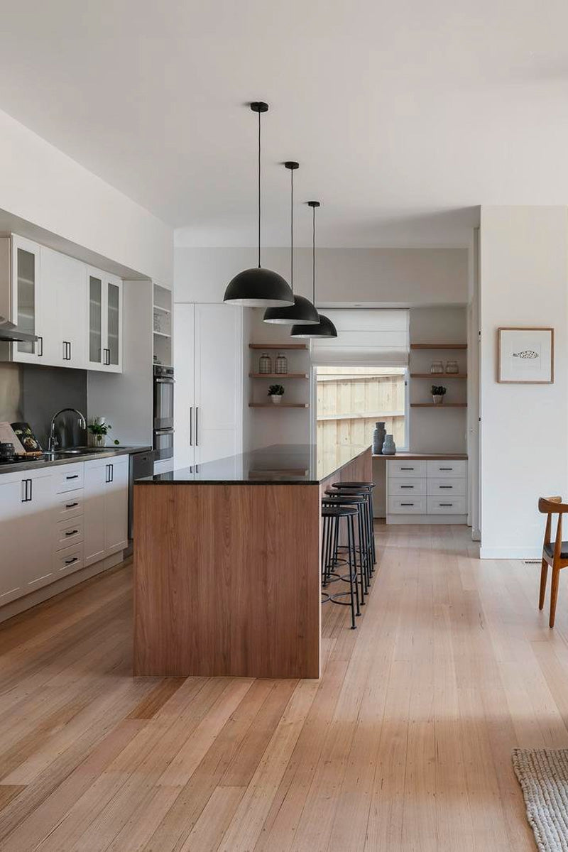 three dome pendant lights over long kitchen island