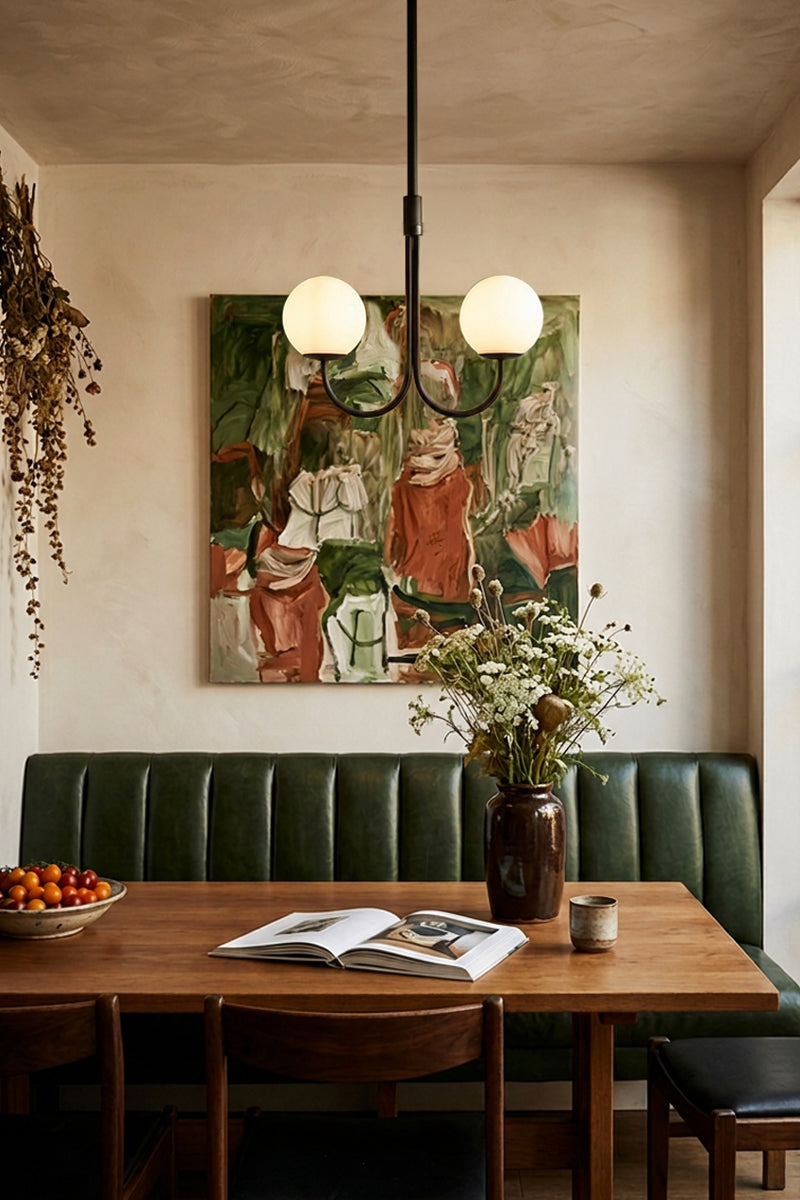 Bonnie Glass Double Chandelier suspended above a timber dining table in a warm, contemporary dining room