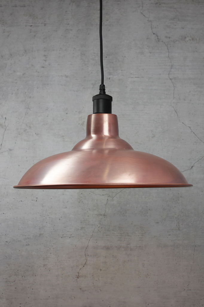Solid copper bullpit shade on a black pendant cord.