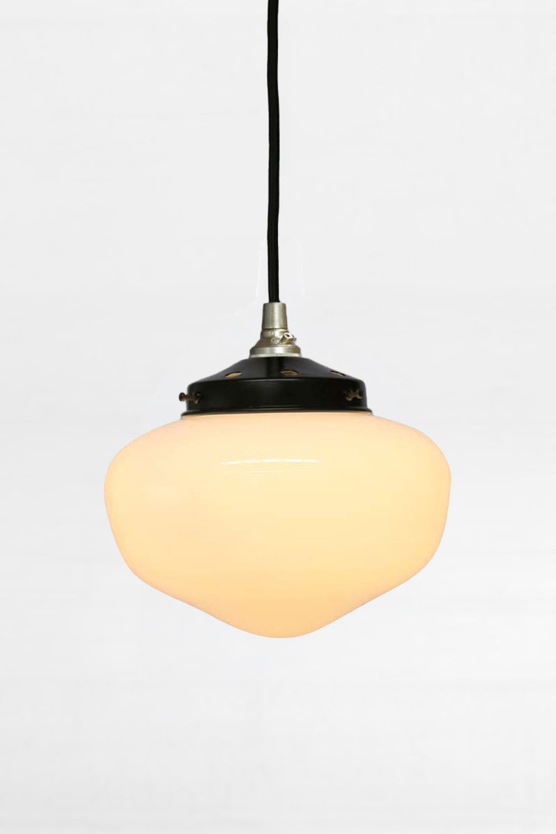 Medium opal glass shade ith a black fabris cord with gold hardware and  a black gallery. 
