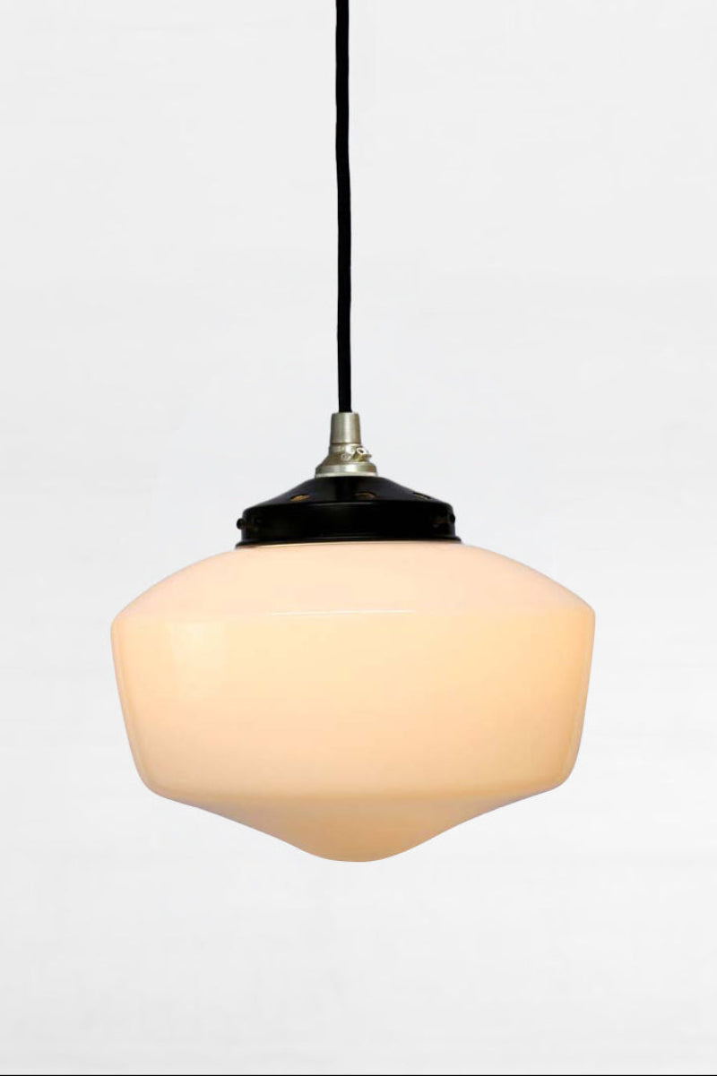 Medium opal galss shade with a gold/brass pendant cord and black gallery. 