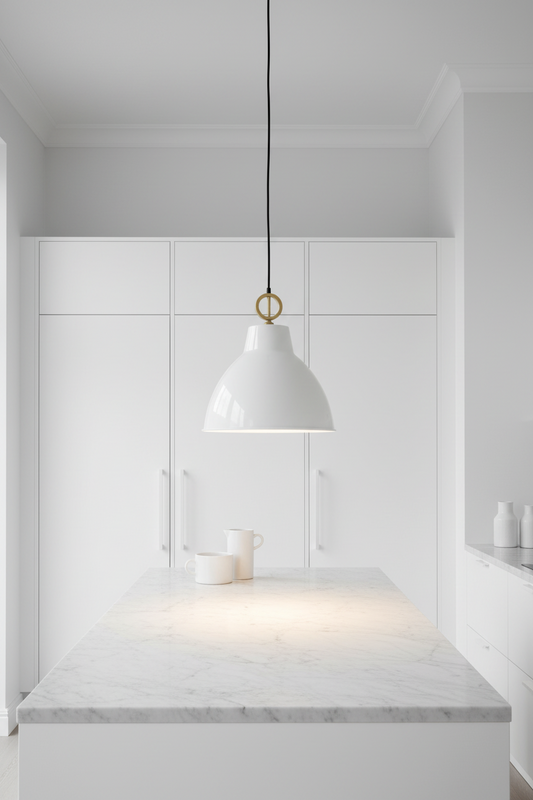 Modern kitchen with white cabinets, marble countertop, and a white pendant light.