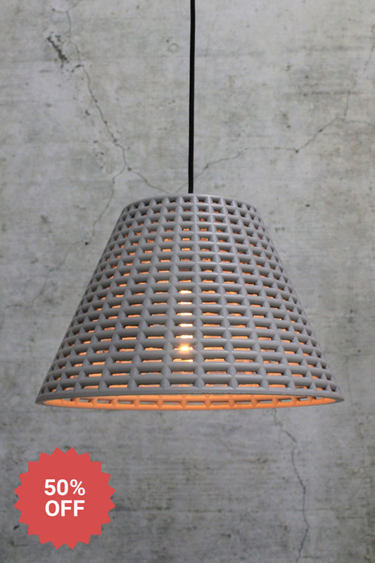 Pendant light with a shade constructed of concrete and a black cord.