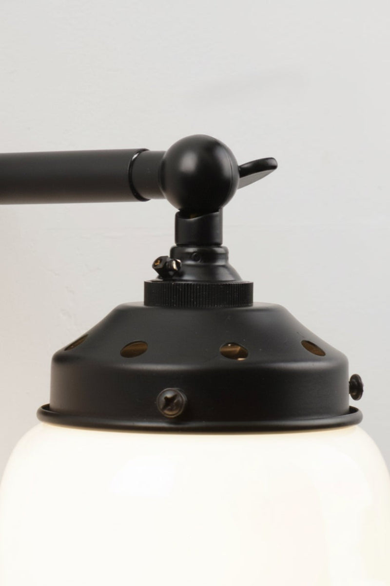 Close up of the tiltable lampholder  on the black chandelier arm. 