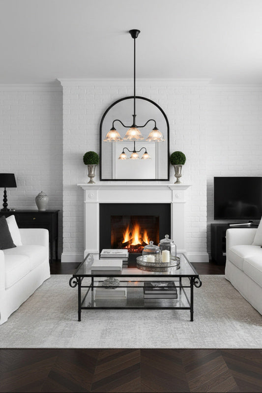 Three arm light with clear decorative shades on a strong steel construction in a living room with wooden floors, white sofa's and open fire place.