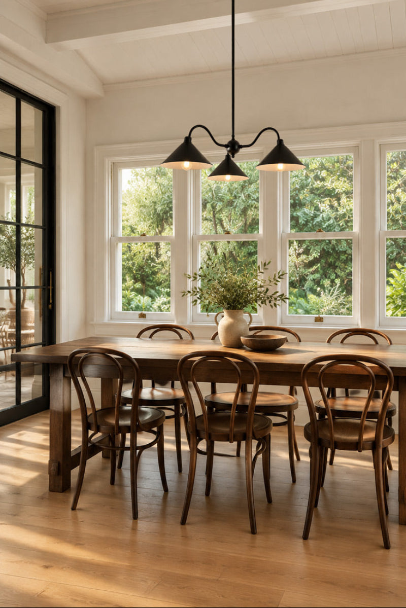 Cone Gooseneck Chandelier in black over wooden table in home dining room. Kitchen dining modern vintage