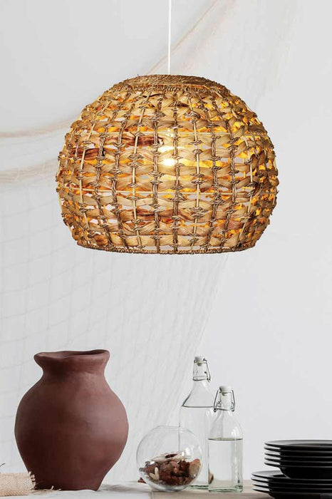 Rattan pendant light with white cord over dining table