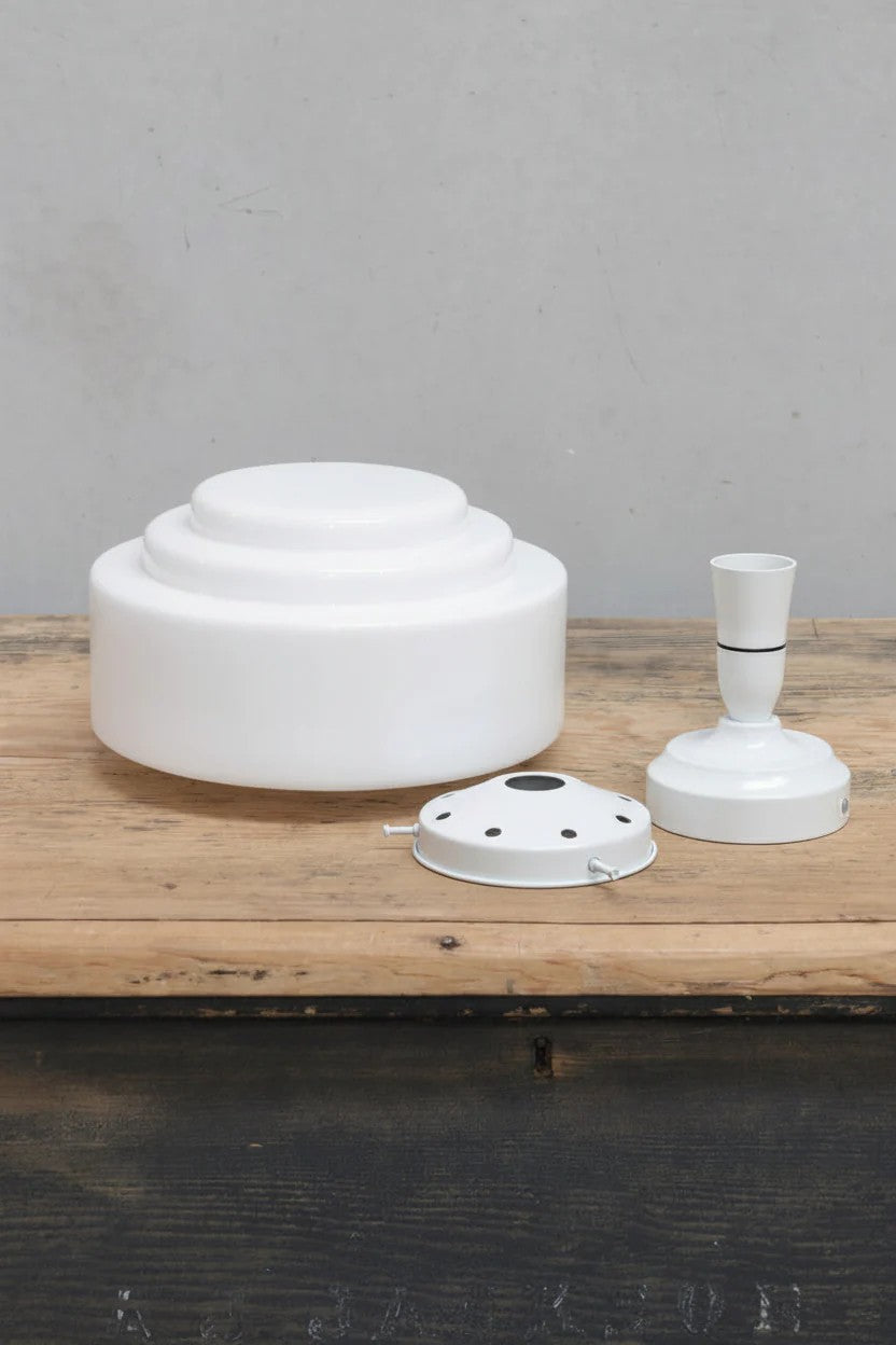 Unistalled opal glass shade with stepped silluette and a white gallery and batten holder. 