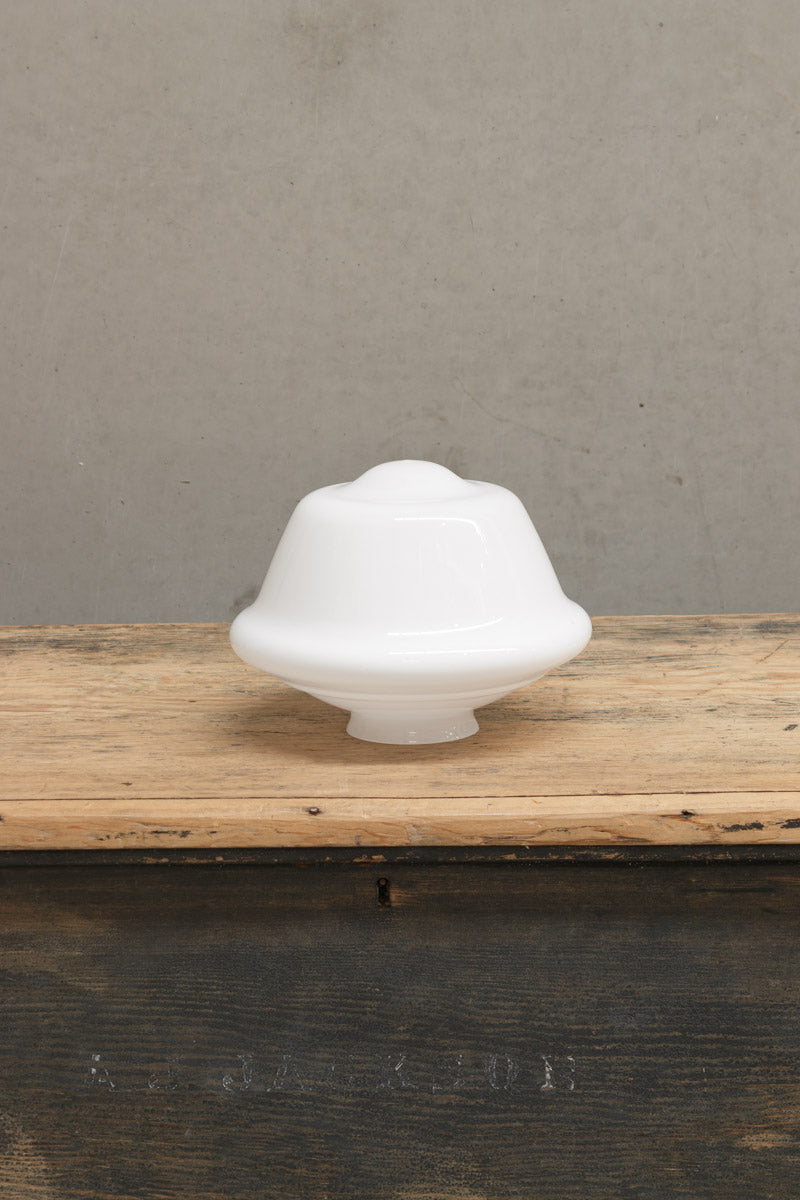 Small opal Chelsea school house shade on a timber bench. 