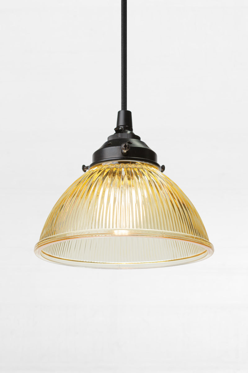 Amber glass shade with reeded detailing on a black pendand cord
