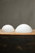 Small and large dome opal shades sitting on timber bench.