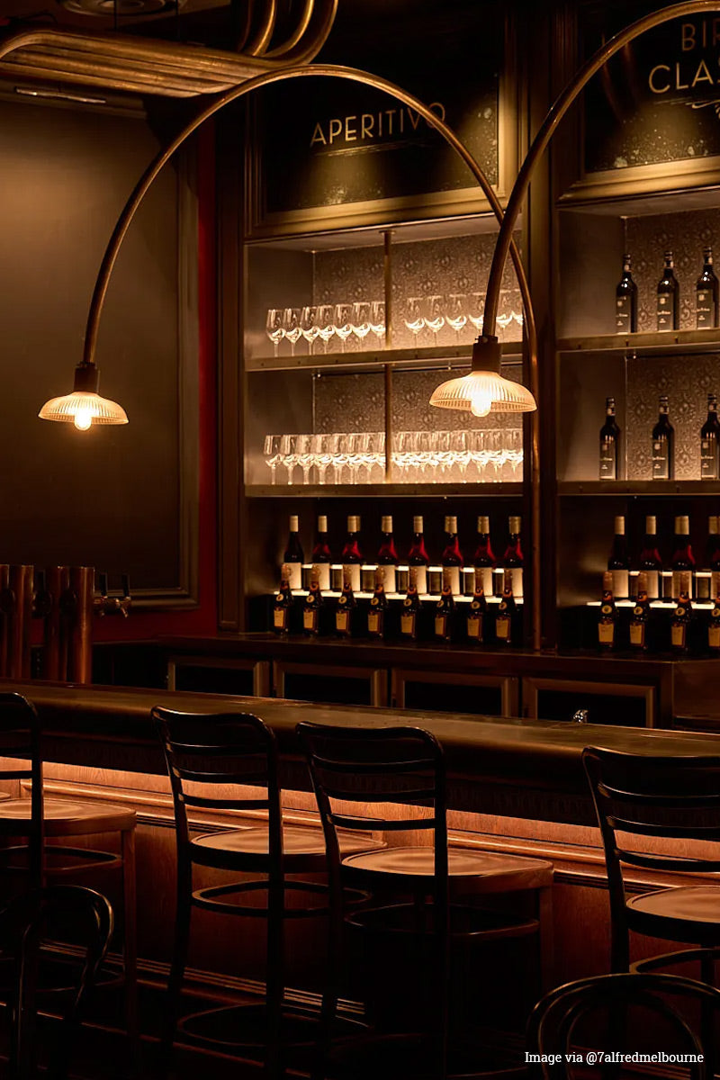 Imaage via @7alfredmelbourne: Two reeded open glass shades on oversized curved pole light fixtures in an urban bar. 