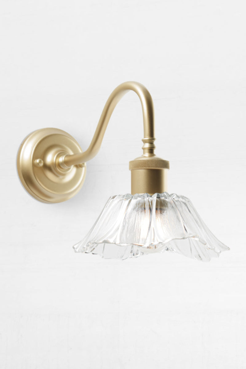 Sculptured glass shade on gold wall sconce