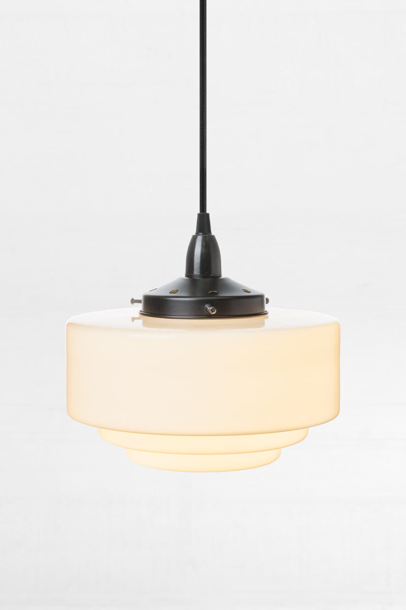 Opal schoolhouse shade with stepped detailing and a black endant cord. 