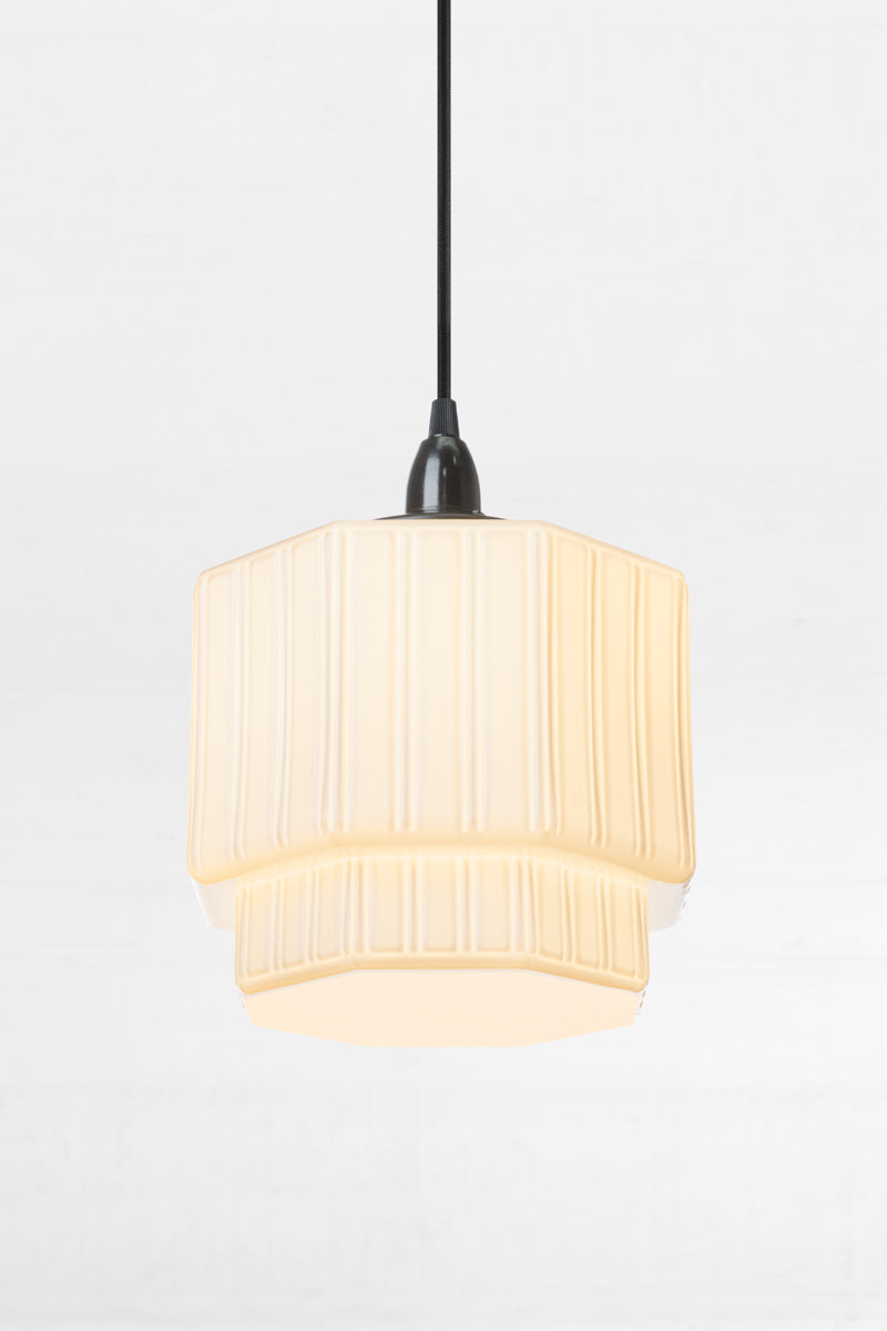 Art deco inspired shade on a black pendant cord. 