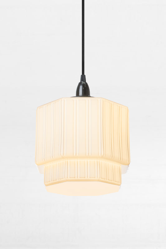 Art deco inspired shade on a black pendant cord. 