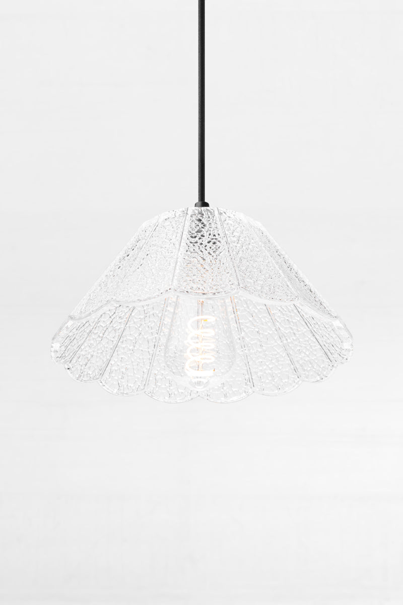 Clear crackle glass shade with scalloped edge on a black cloth pendant cord, paired with a teardrop bulb. 