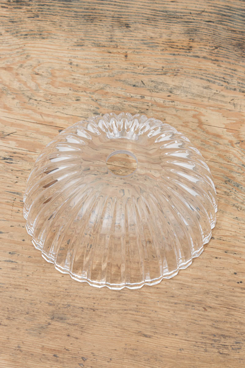 Top view of the clear glass shade uninstalled placed on a timber bench. 
