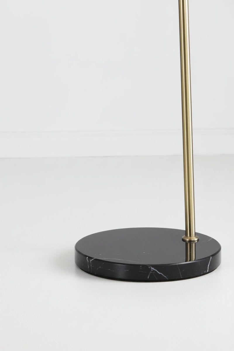 Close-up of the antique brass lamp with black marble base in a white room. 