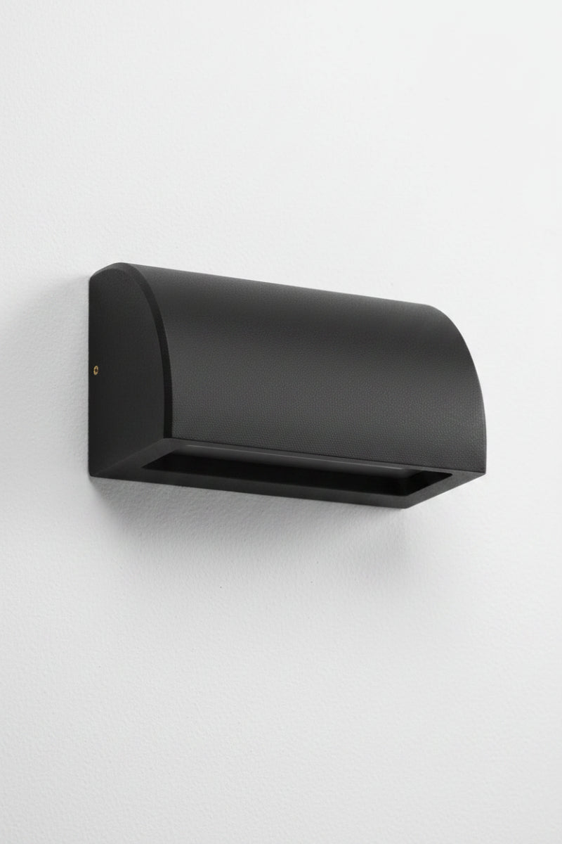 Large curved matt black step light with a downward light on a white exterior wall. 