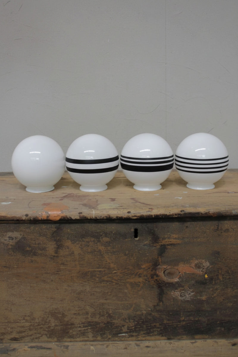 Four opal glass ball shades, three with black painte stipes detailings. 