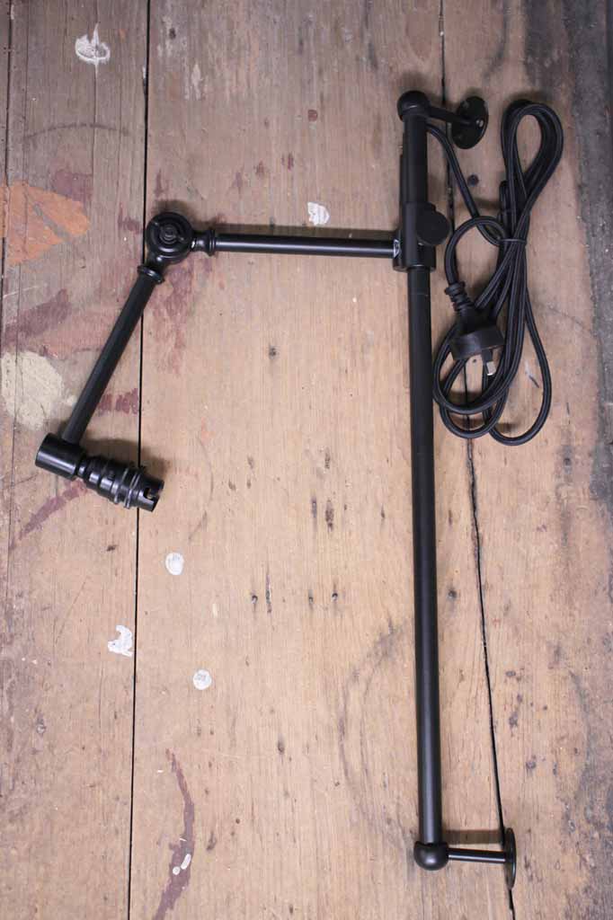 Black swing arm wall light fixture, uninstalled. 