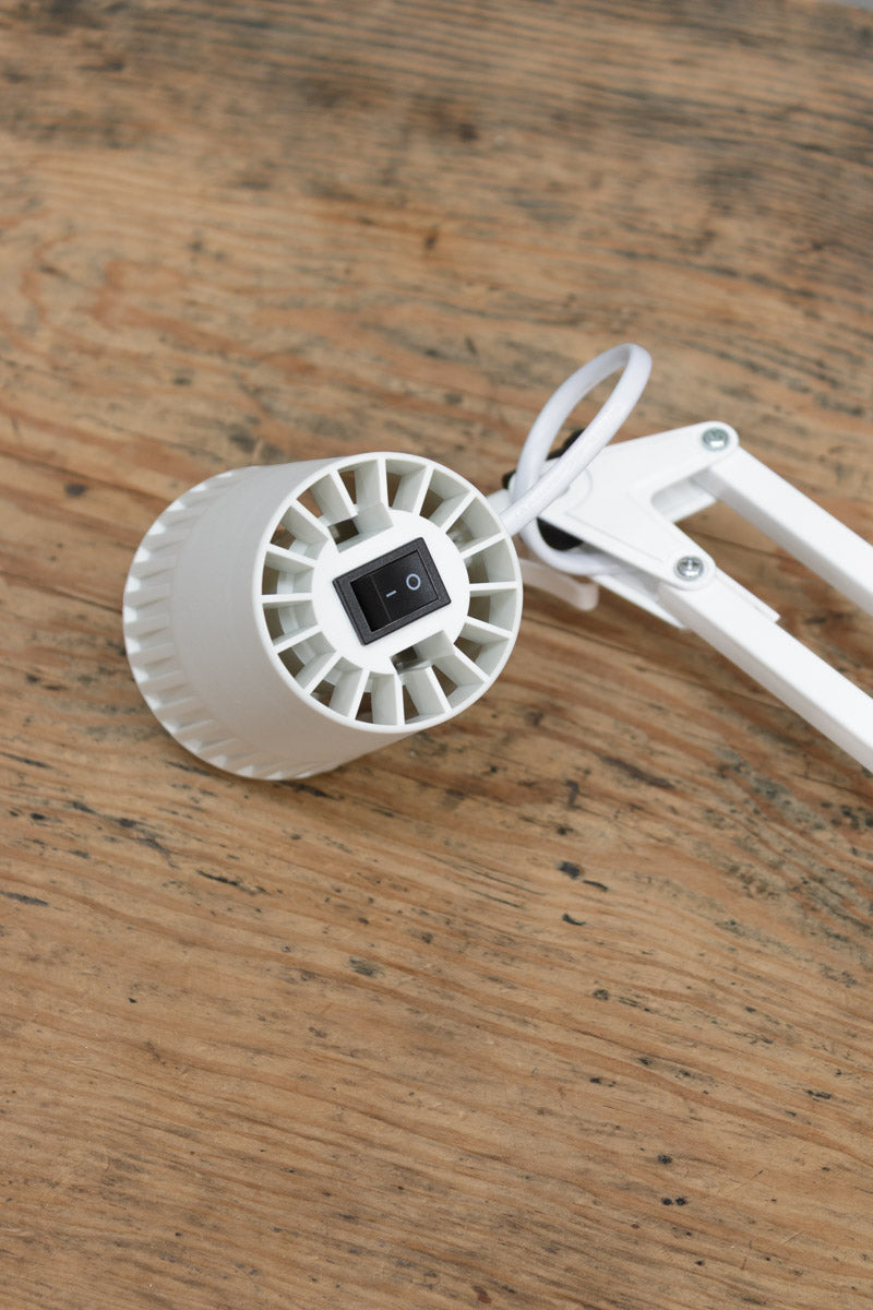 Close up of the swtich on the top of the white desk lamp