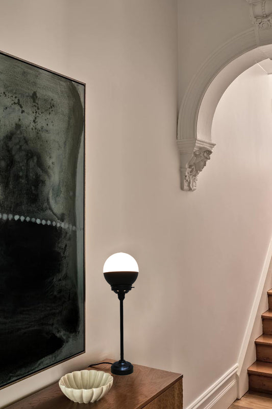 Black crown shade table lamp on entrance table. 