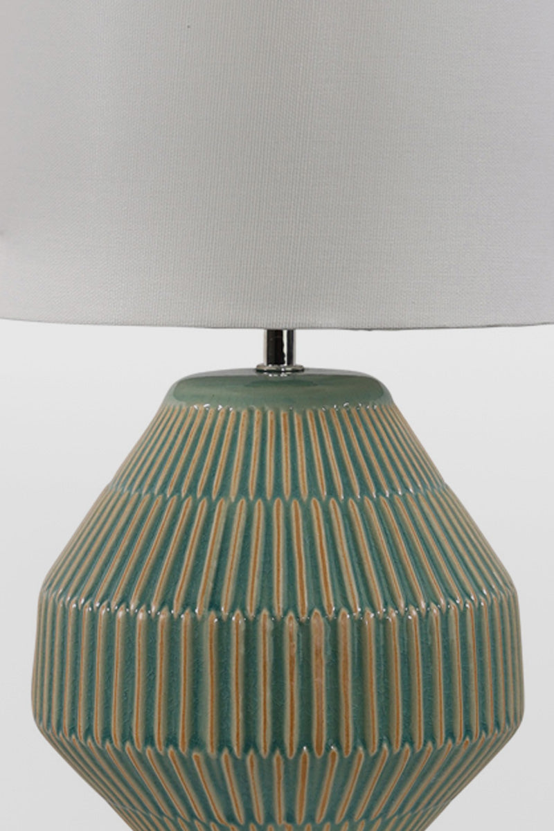 Close up of the green textured ceramic based table lamp with a white fabric shade.