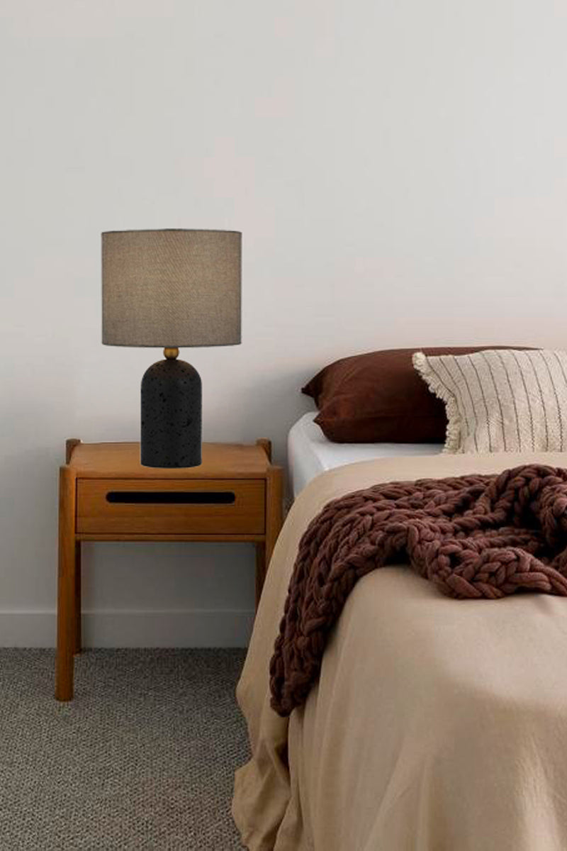 Black table lamp with fabric shade as a bedside table. 
