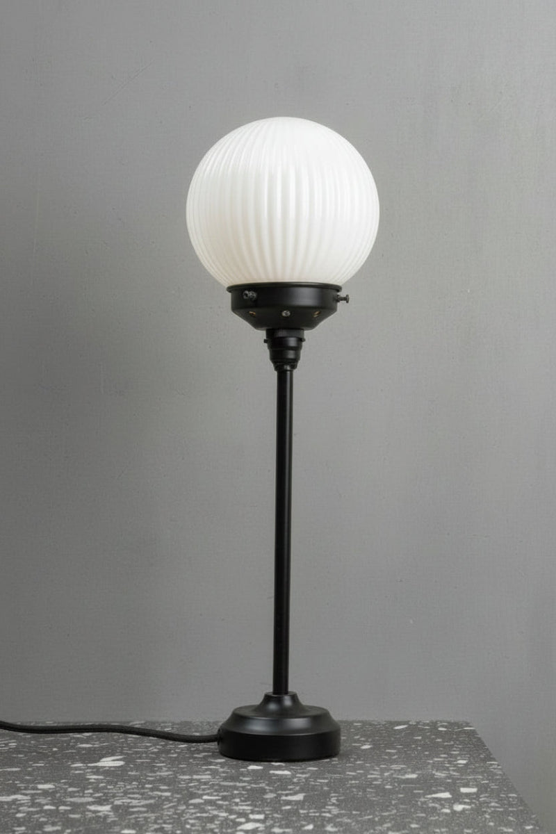 Black candlestick table lamp with an opal reeded glass ball shade. 