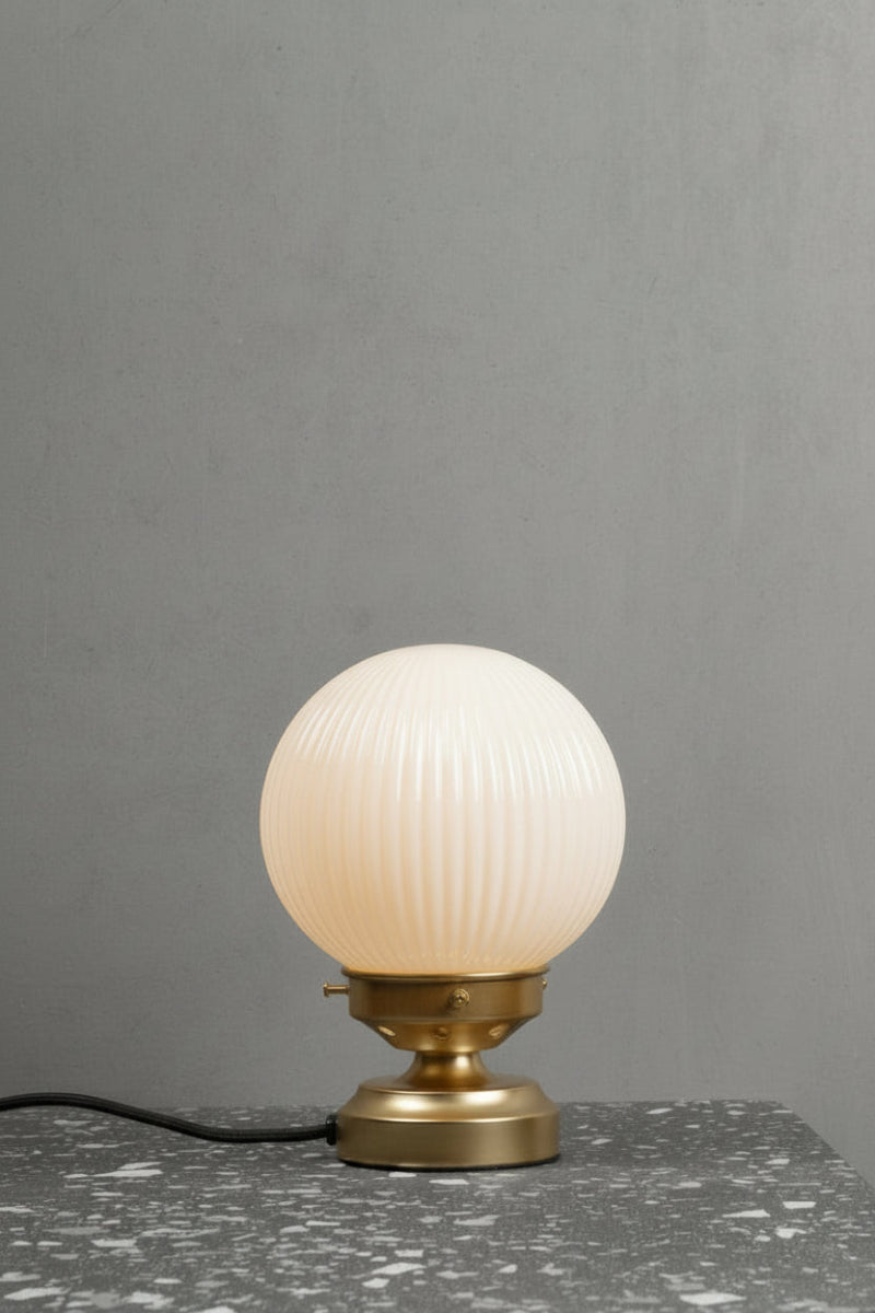 Reeded opal glass ball shade on a gold/brass short table lamp stand. 