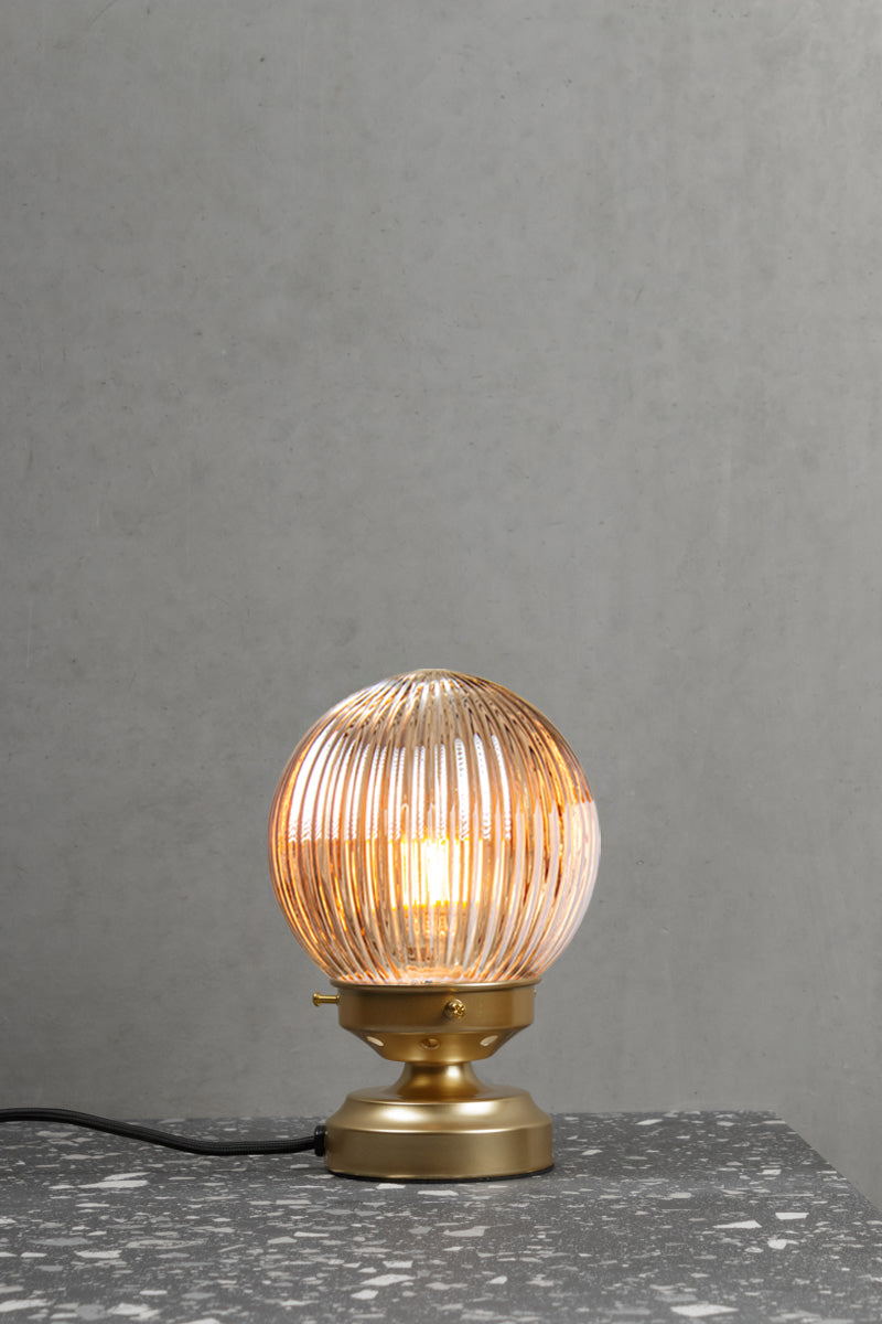 Dark amber reeded glass ball lamp with a gold/brass base. 